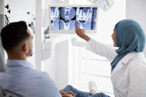 root canal treatment muslim female dentist showing x-ray