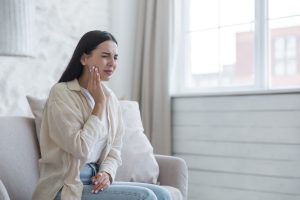 woman sitting on a couch with a dental trauma and dental injury