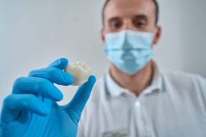 dentist holding tooth and preparing for successful re-implantation