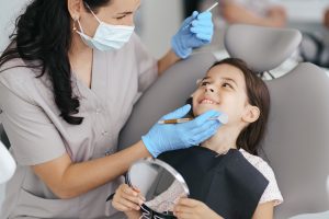 dental hygienist checking a little girls teeth